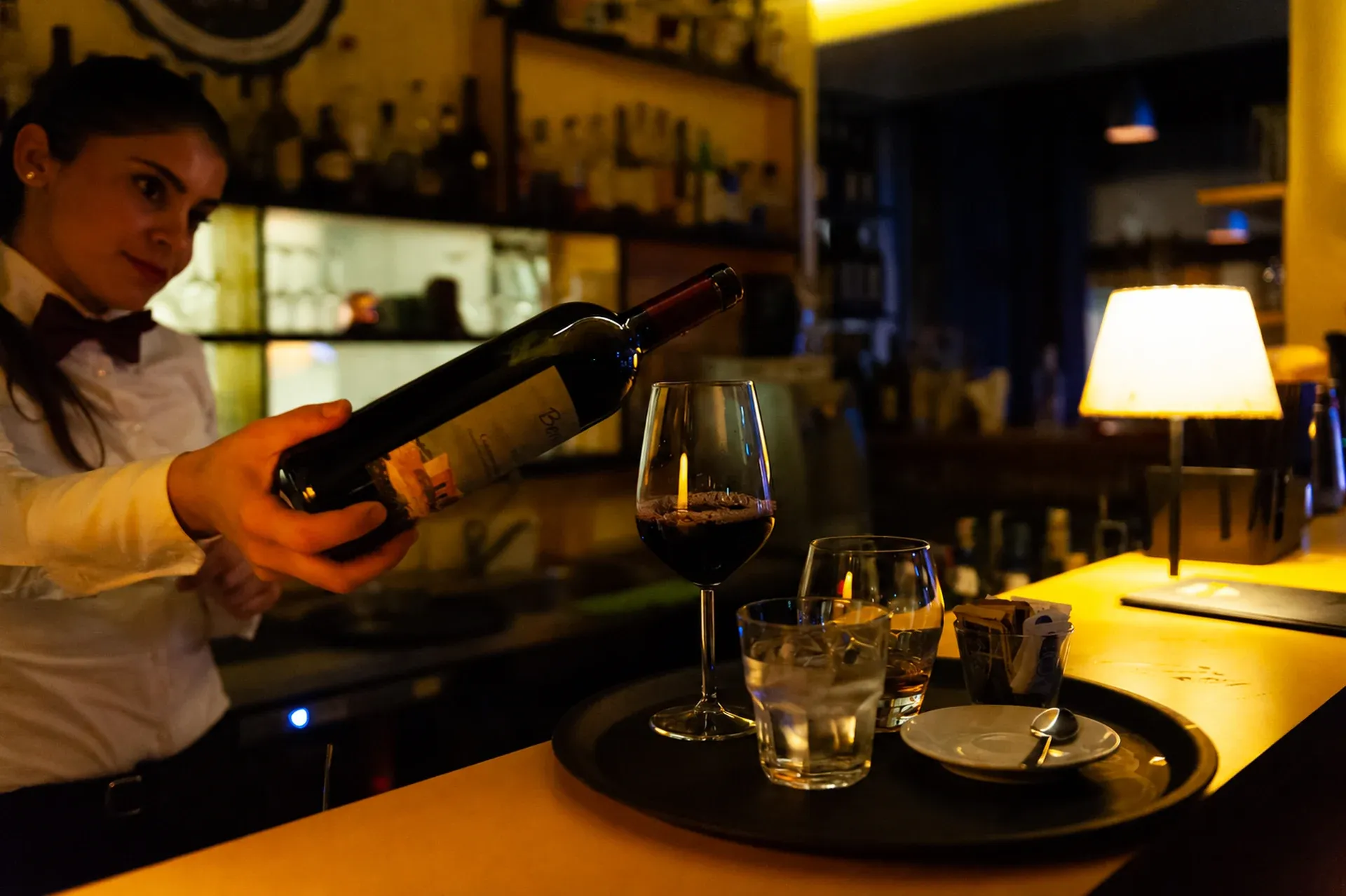 Cameriera che serve il vino al tavolo nel ristorante del Jazzino a Cagliari